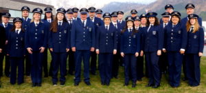 Ørsta hornmusikk står oppstilt i blå uniformer ute